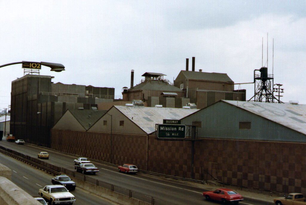 A view of some buildings and cars on the road.